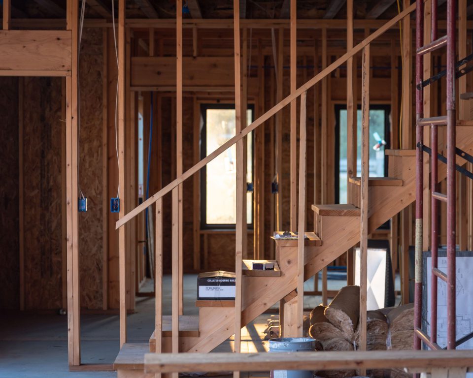 Timber framing and staircase inside a house under construction, the structure examined during home inspection services in Greenville, TX.