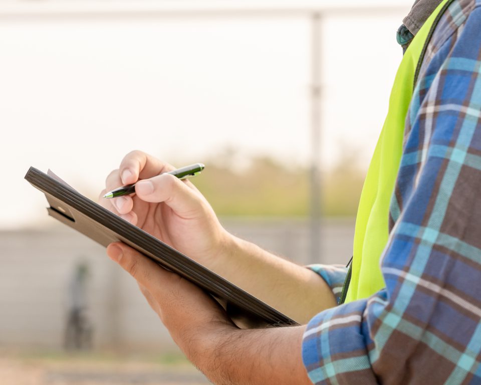 Inspector recording findings on a clipboard during home inspection services in Greenville, TX.